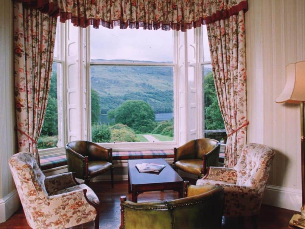 Un coin salon avec vue sur un loch au Glengarry Castle Hotel à Invergarry