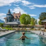 Une femme se baigne dans la piscine du Château Brachet, un des meilleurs hôtels châteaux de Rhône-Alpes