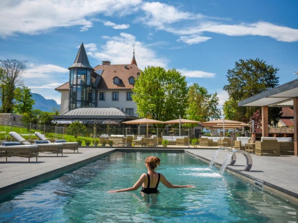 Une femme se baigne dans la piscine du Château Brachet, un des meilleurs hôtels châteaux de Rhône-Alpes